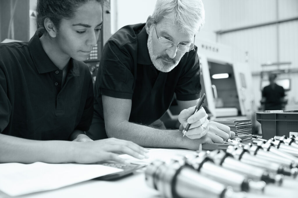 Engineer And Apprentice Planning CNC Machinery Project